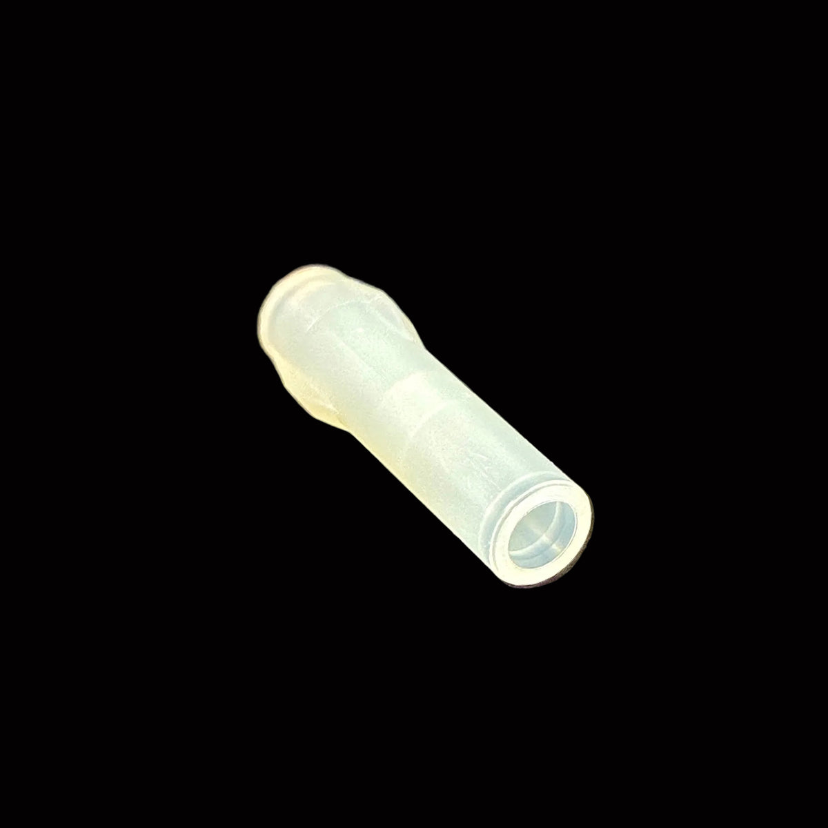 A small translucent plastic connector piece, likely a male audio jack plug, resting on a black surface.