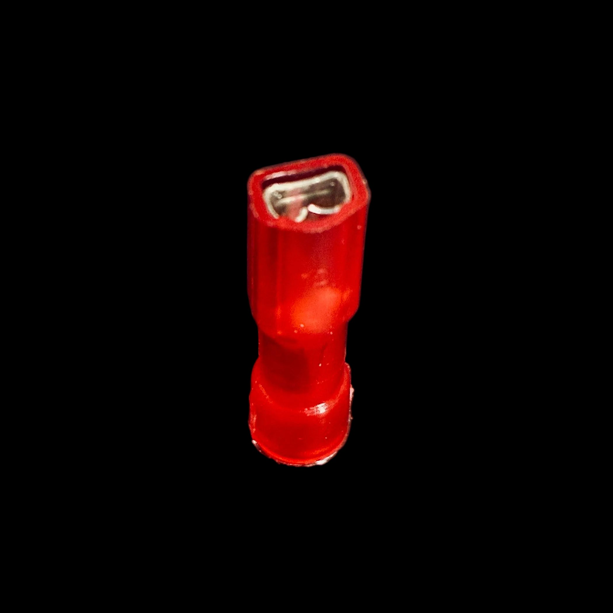 A small red translucent plastic electrical connector with a silver metal contact inside, standing upright on a black background.